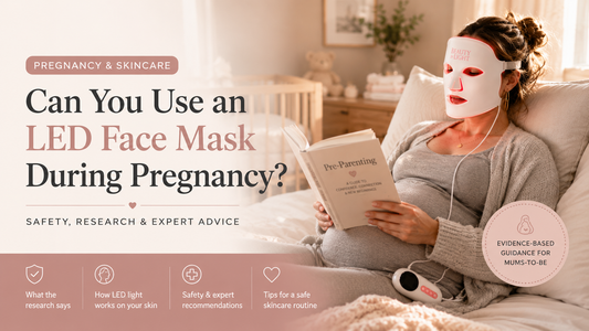 Pregnant woman using a Beauty by Light LED face mask while reading in bed, illustrating at-home LED light therapy during pregnancy in a comfortable bedroom setting.